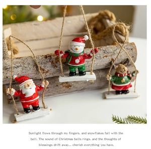 Detail of Santa, snowman, and reindeer resin figurines on swings with hanging hemp rope