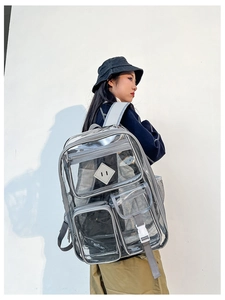 Zaino trasparente in PVC con spallacci grigi mostrato su modello contro parete
