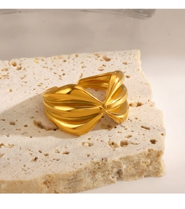 Macro detail of 18K gold plated open ring with unique irregular wave texture on travertine