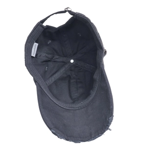 Detail of distressed brim and adjustable metal buckle on a black vintage baseball cap