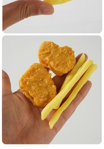 Macro shot of realistic fried chicken and french fries models held in hand showing texture