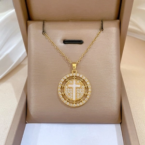 Detailed view of luxury gold cross necklace with crystals in an elegant jewelry box