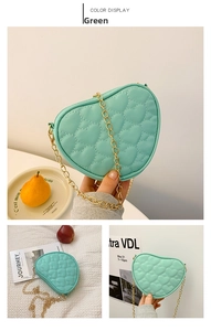 Detail view of mint green heart-shaped quilted bag with elegant gold chain strap