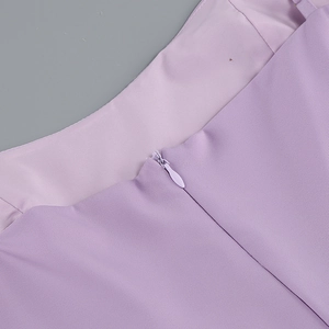 Detailed close-up of invisible zipper and woven fabric texture on purple evening gown