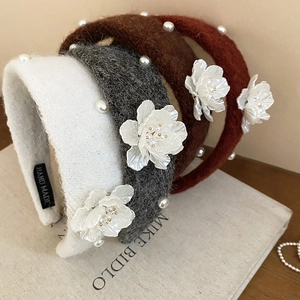 Close-up of velvet floral headbands with pearls and hand-made tags in assorted colors