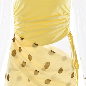 Détail du haut bandeau jaune plissé et de la jupe longue à pois marrons sur le mannequin