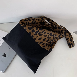 Detailed view of leopard print canvas tote bag with black stitching and spacious interior