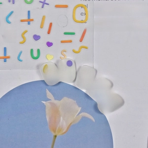 Macro shot of 5D white translucent nail art stickers with colorful embossed letters