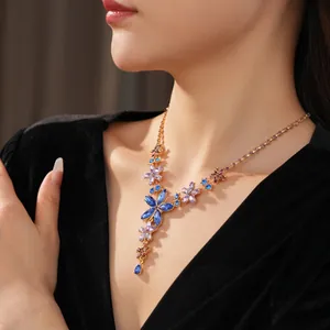 Vintage style floral crystal necklace with blue marquise stones and gold tassels on model