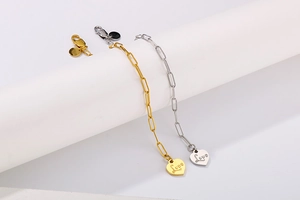 Detail showing gold and silver heart pendants with Love engraving on stacking chains