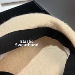Detail shot of lamb wool beret interior showing the black elastic sweatband and stitching
