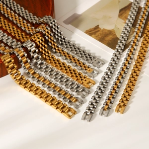 Polished 18k gold and silver stainless steel watch-style bracelet set on wood