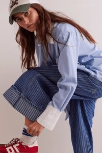Senkrecht gestreifte Wide-Leg-Jeans kombiniert mit Hemd und Retro-Sneakern