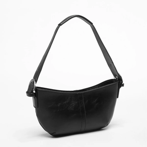 Classic black glossy leather crescent underarm bag with adjustable strap on white backdrop
