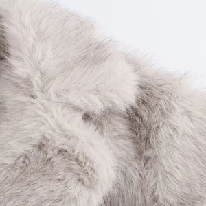 Gros plan sur la texture de fourrure synthétique grise montrant des fibres douces et denses