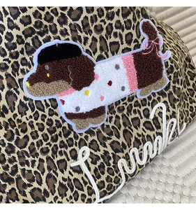 Close-up of leopard print tote bag with 3D dachshund embroidery in pink sweater