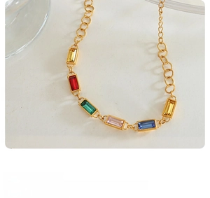 Macro shot of gold-plated necklace with colorful rectangular cut zircons in a vintage style