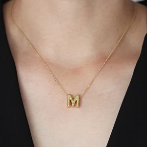 Primo piano della collana con ciondolo lettera M minimalista placcata oro 18k
