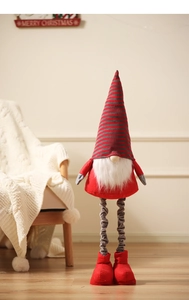 Detail of Christmas gnome with long striped legs and Merry Christmas sign in a home setting