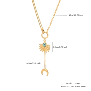 Detail view of gold stainless steel necklace with sun pendant and crescent moon tassel