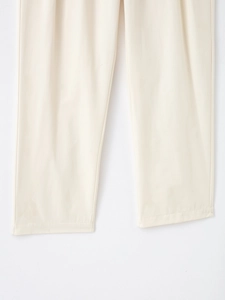 Détail du pantalon décontracté blanc cassé avec texture fine et ourlet bien cousu