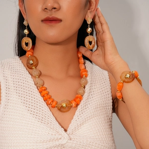 Detailed close-up of amber acrylic bead jewelry set worn by a model in a retro style