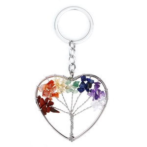 Detailed view of handmade heart-shaped Tree of Life keychain with colorful natural crystals