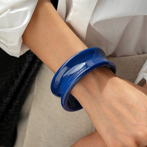 Détail d'un bracelet jonc en résine bleue montrant une finition brillante sur un mannequin