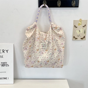 Dettaglio della borsa tote in tela trapuntata a fiori con manico in corda intrecciata