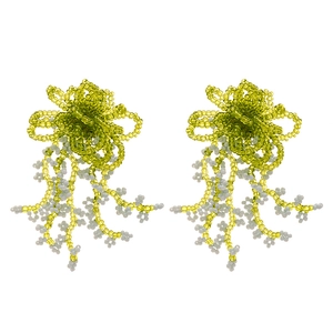 Handmade green and yellow beaded bow earrings with boho fringe on a white background