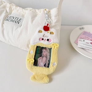 Close-up of yellow plush animal photocard holder with cherry and star embroidery detail