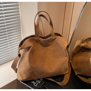 Close-up of brown canvas tote bag on a desktop with mirror and decorative books