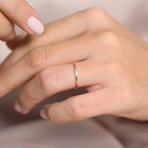 Macro detail of slim 18K gold ring featuring three sparkling inlaid zircon stones