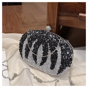 Detail of pumpkin shaped evening bag with rhinestones and black white stripes