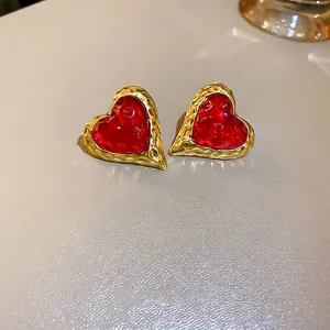 Vintage hammered gold heart earrings with vibrant red resin inlay in a retro style