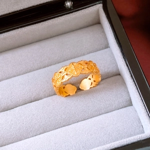 Detailed view of 24k gold plated ring with embossed floral patterns and matte finish