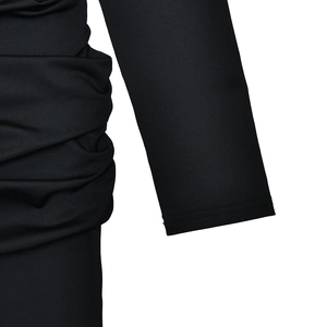 Detailed macro view of the ruched side seam and black fabric texture on the long sleeve dress
