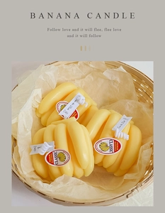 Detailed view of banana-shaped candles in a woven basket with warm natural lighting