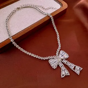 Collier élégant avec nœud en argent et cristaux de zircon brillants sur soie rouge