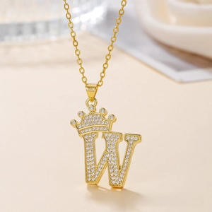 Close-up of golden crown letter W necklace pendant with cubic zirconia inlay detail