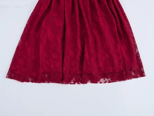 Gros plan détaillé sur la dentelle florale rouge et l'ourlet de la robe courte