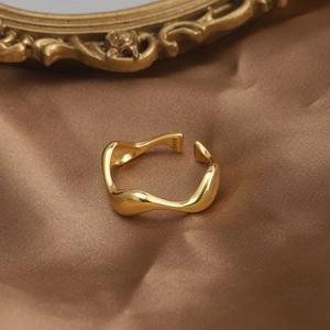 Detailed macro shot of irregular wavy S925 sterling silver ring with golden finish