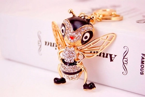 Close-up of golden honey bee keychain with sparkling rhinestones and black enamel detail