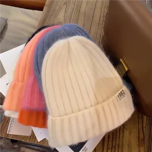 Detail of soft knit beanies with 1982 California label in various pastel colors