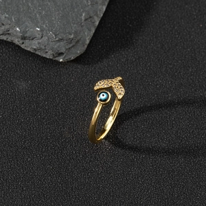 Detailed view of gold fishtail ring with white zircon and blue enamel evil eye element