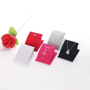 Présentoirs à colliers en velours de couleurs variées sur fond blanc épuré