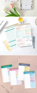 Flat lay of colorful daily planners with daily goals, checklist, and meal tracker sections
