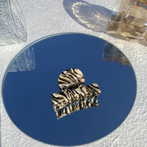 Macro detail of acetate hair claw clip with black and white marble pattern on mirror