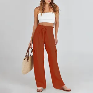 Detail of drawstring waist and cargo pockets on rust red wide leg cotton linen pants