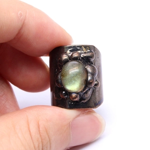 Macro shot of vintage bronze ring featuring labradorte stone with floral textures